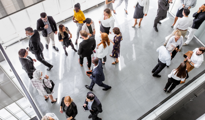 Vue de haut de plusieurs groupes de personnes discutant dans un hall